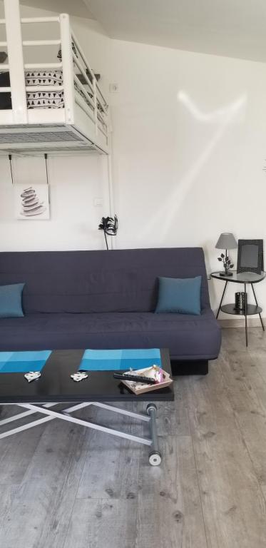 - un salon avec un canapé bleu et une mezzanine dans l'établissement studio 2, à Saint-Martin-la-Plaine