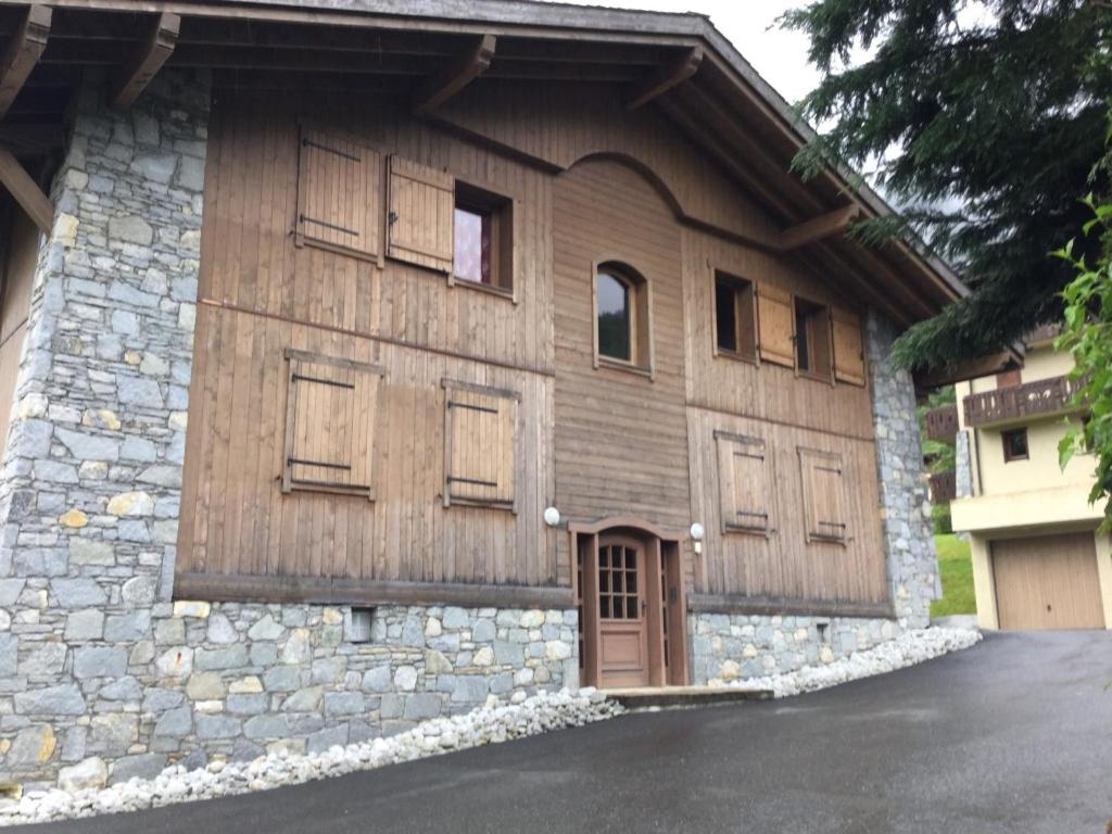a building with wooden doors and windows on it at Apartment Le Kandahar in Les Houches
