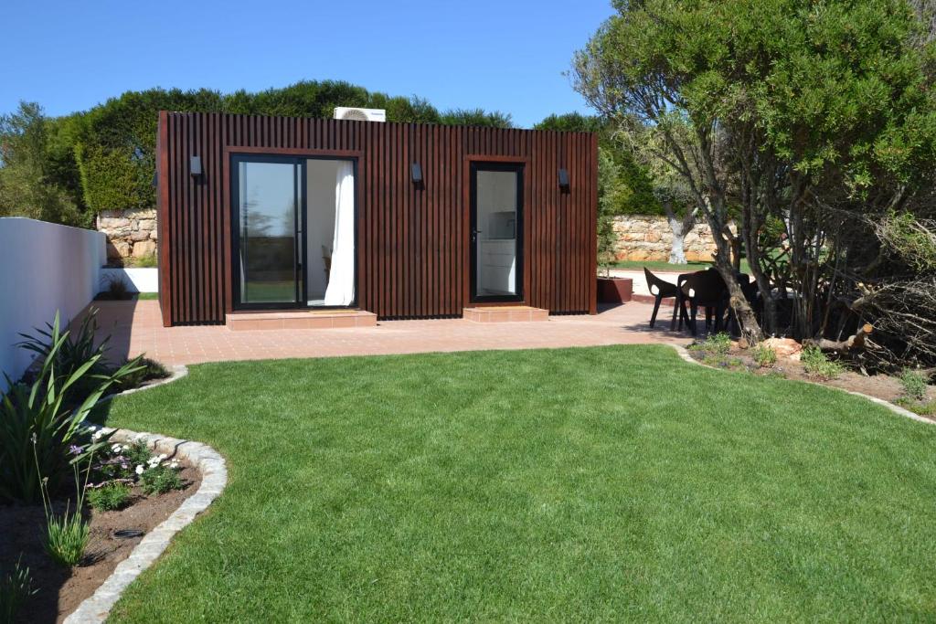 une petite maison avec une pelouse verte en face de celle-ci dans l'établissement Casa Kube, à Sagres