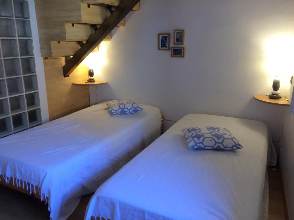 two twin beds in a room with a staircase at Appartement rénové à 50 m de COLLIOURE Plage, Entrée autonome, Climatisé in Collioure