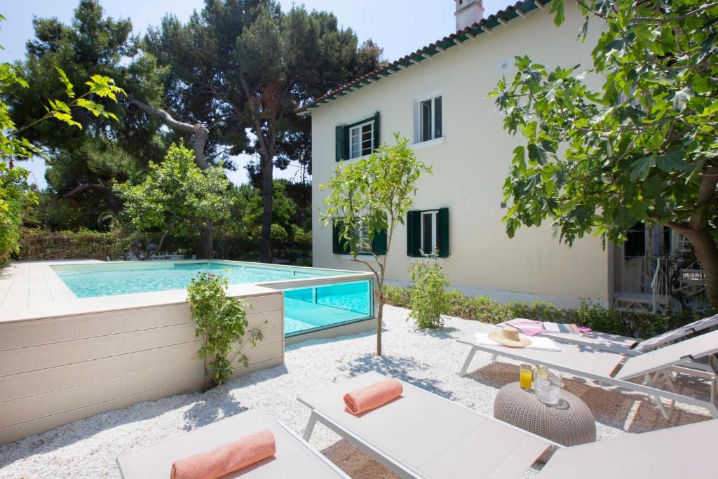 a villa with a swimming pool and a house at Villa1951 in Glyfada in Athens