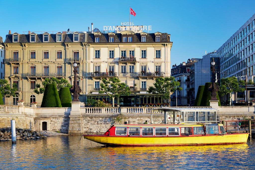 a yellow boat in the water in front of a building at Hotel d'Angleterre in Geneva