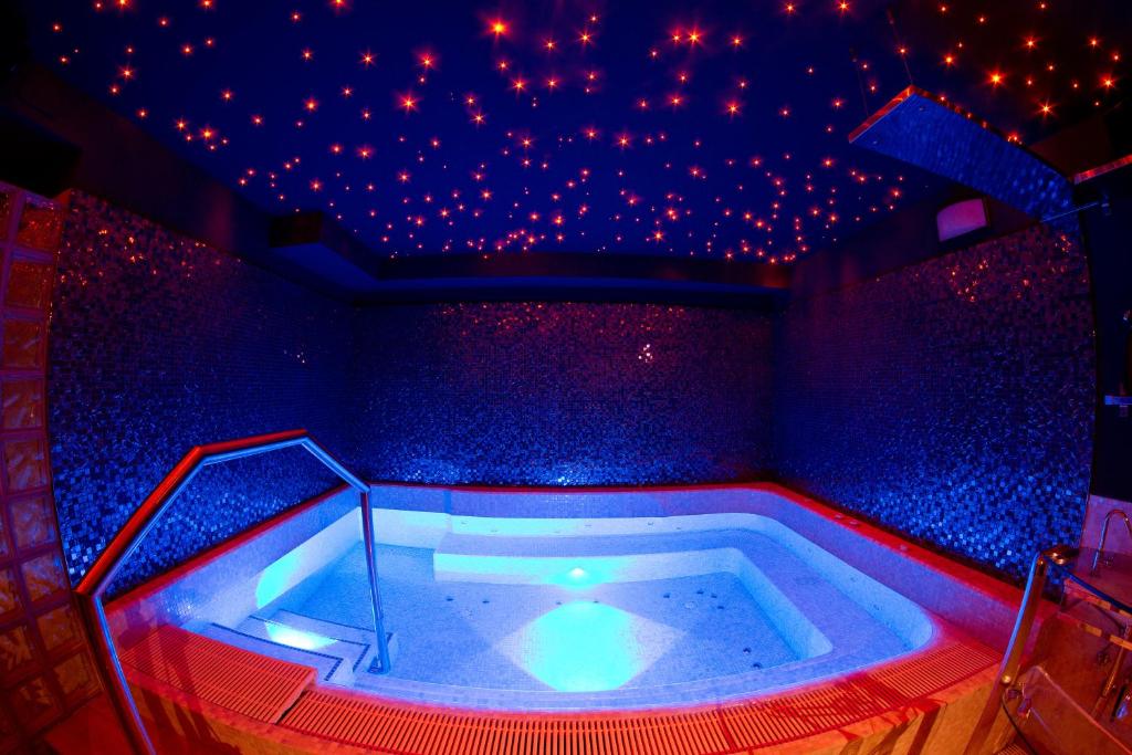 - un bain à remous dans une chambre avec des lumières rouges dans l'établissement new emotion room, à Trieste