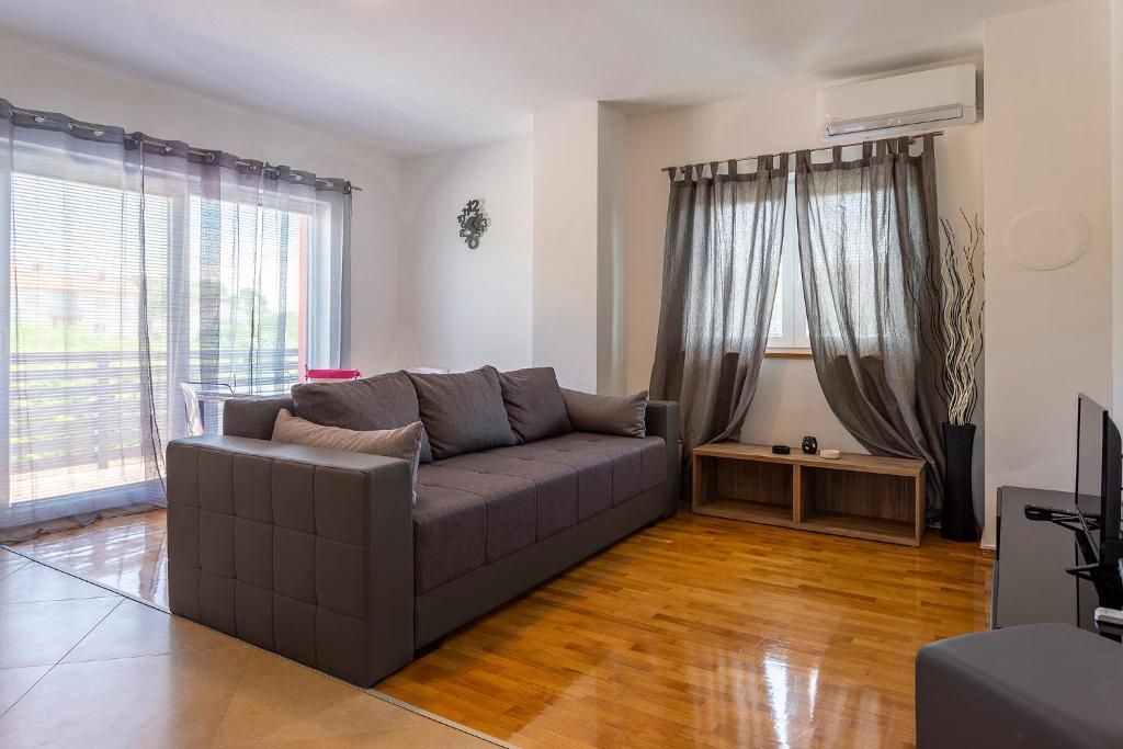 een woonkamer met een bank en een televisie bij APARTMANI KAROCA in Pula