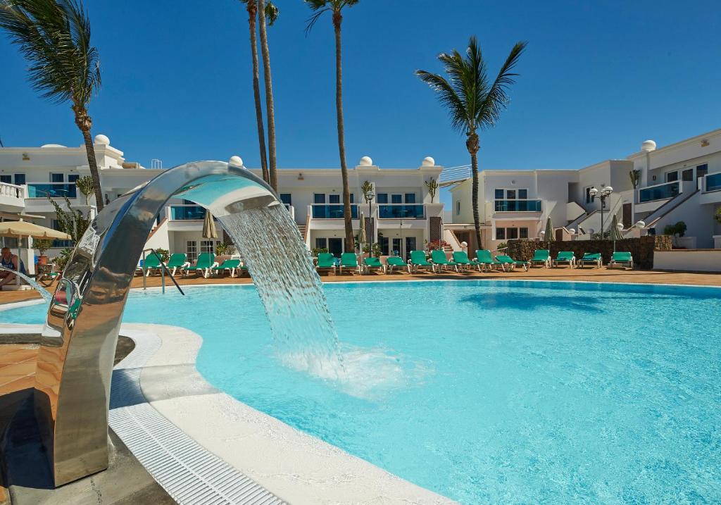 un tobogán de agua en una piscina con palmeras en Hotel Suite Montana Club, en Puerto del Carmen