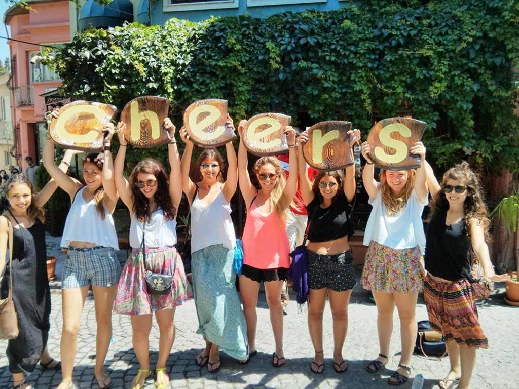 um grupo de raparigas a segurar cartazes com em Cheers Hostel em Istambul