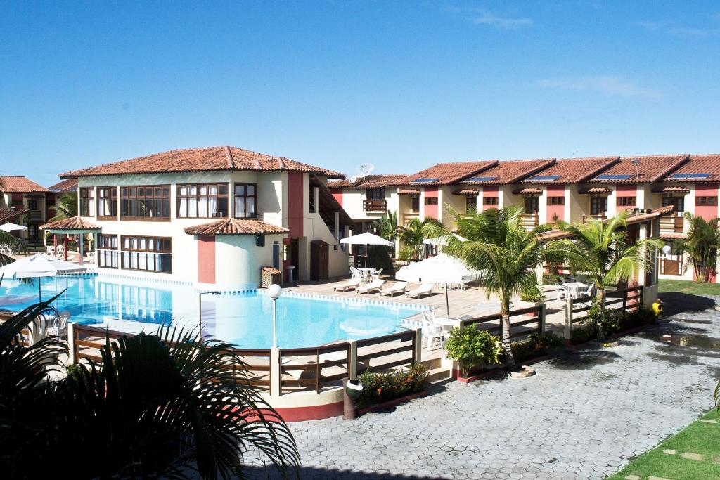 a resort with a swimming pool in front of a building at Residencial Jerusalém I - Tonziro in Porto Seguro