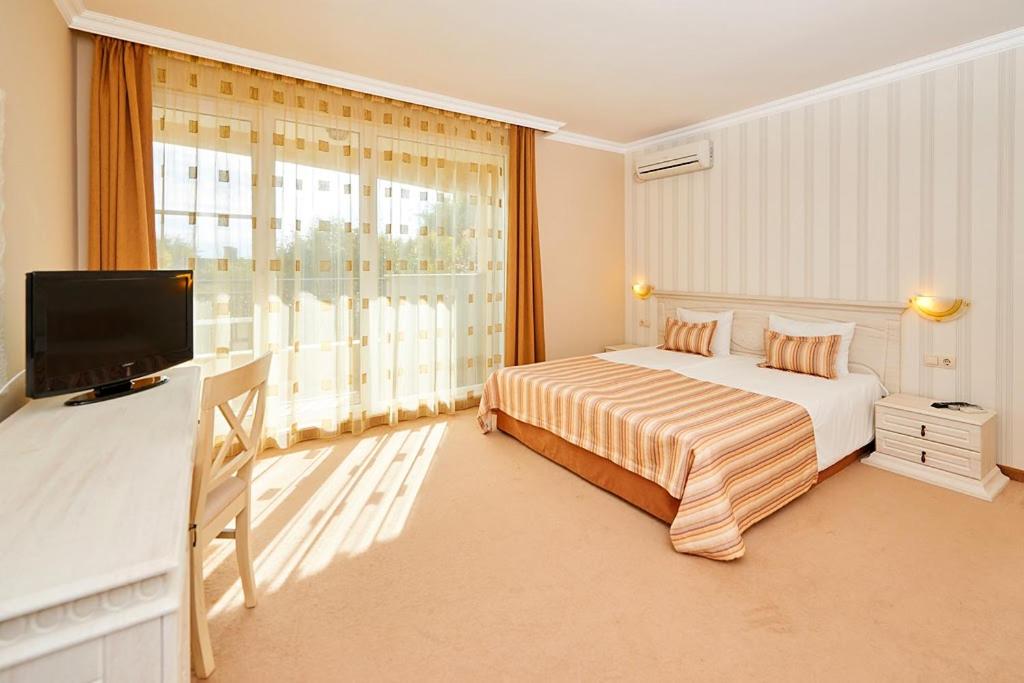 A bed or beds in a room at Penelopa Palace Apart Hotel & SPA