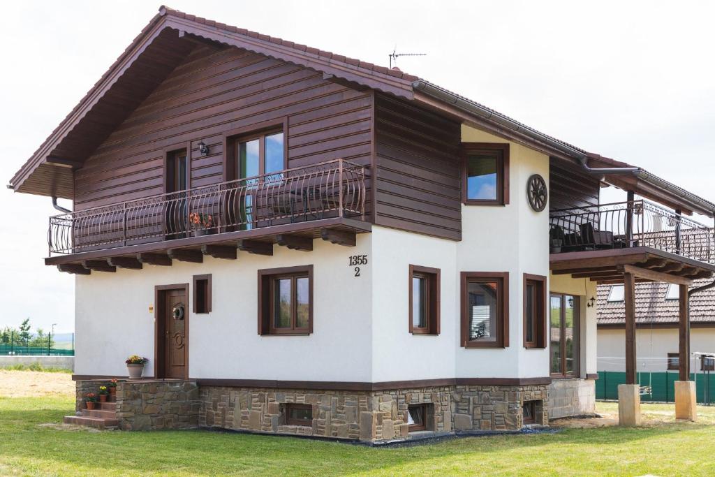 een huis met een balkon er bovenop bij Privát Simeon - ubytovanie v súkromí in Veľká Lomnica