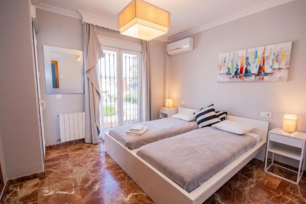 sypialnia z łóżkiem i dużym oknem w obiekcie Cubo's Villa Yedra Guadalmar w Maladze