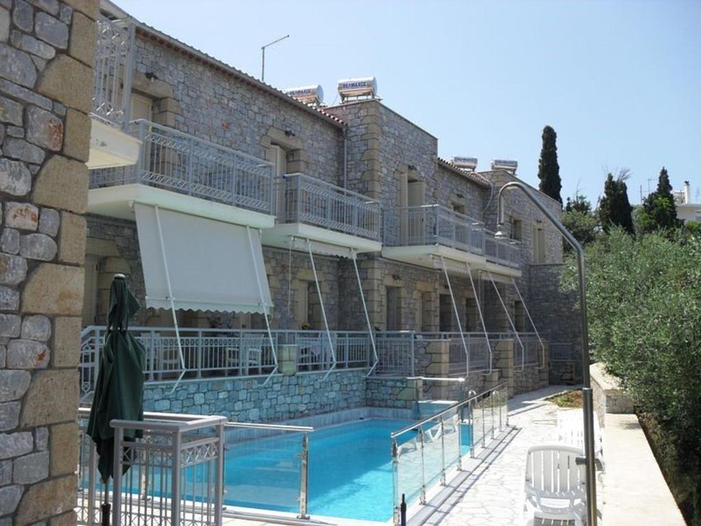 a building with a swimming pool in front of a building at Manoleas Villas - Apartment 4 in Stoupa