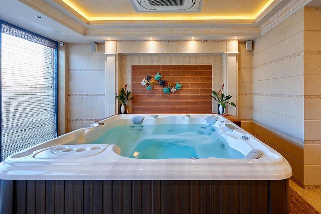 a jacuzzi tub in a large room with at Penelopa Palace Apart Hotel & SPA in Pomorie