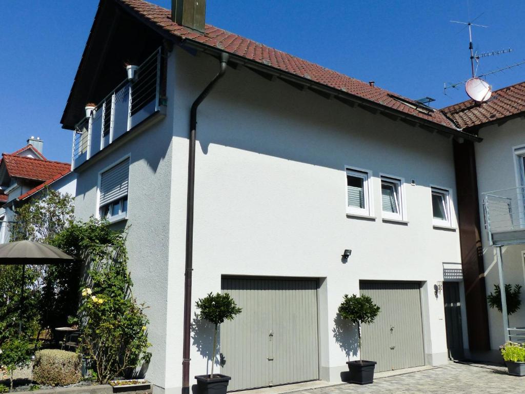 een wit huis met twee garagedeuren bij Ferienwohnung Fürst in Moos