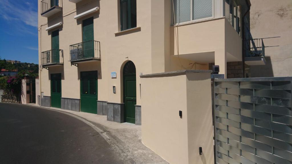 un bâtiment avec des portes vertes dans une rue dans l'établissement Raggio di Sole, à Sorrente