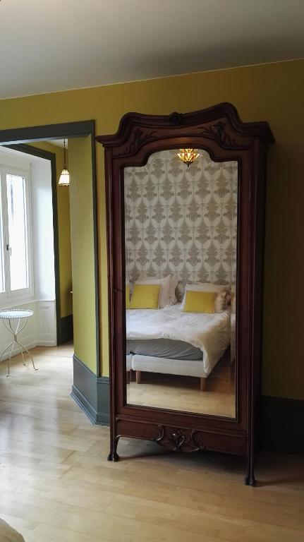 a bedroom with a large mirror on the wall at Résidence de Vaux in Nans-sous-Sainte-Anne