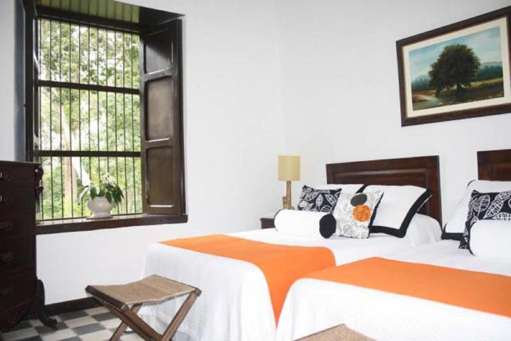 ロス・サントスにあるHotel Hacienda El Robleの白い部屋 ベッド2台 窓2つ付
