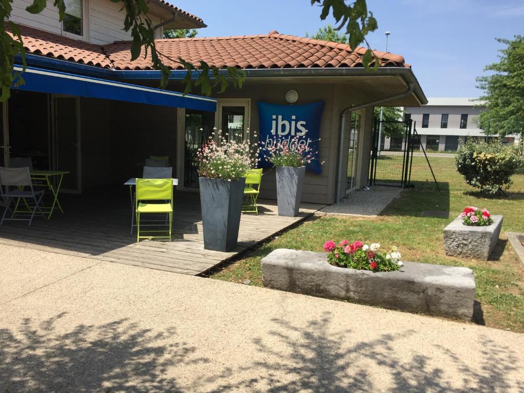 a patio area with a table and chairs in front of a building at ibis budget Bourg en Bresse in Bourg-en-Bresse