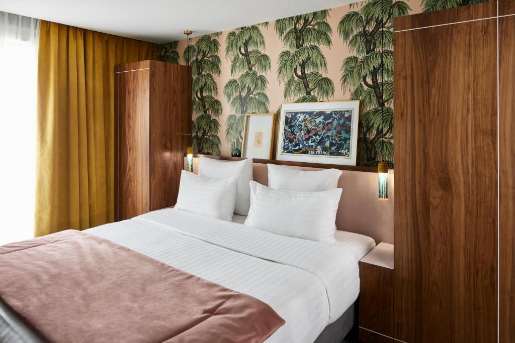 パリにあるホテル テイラーのベッドルーム(白いシーツを使用した大型ベッド1台付)
