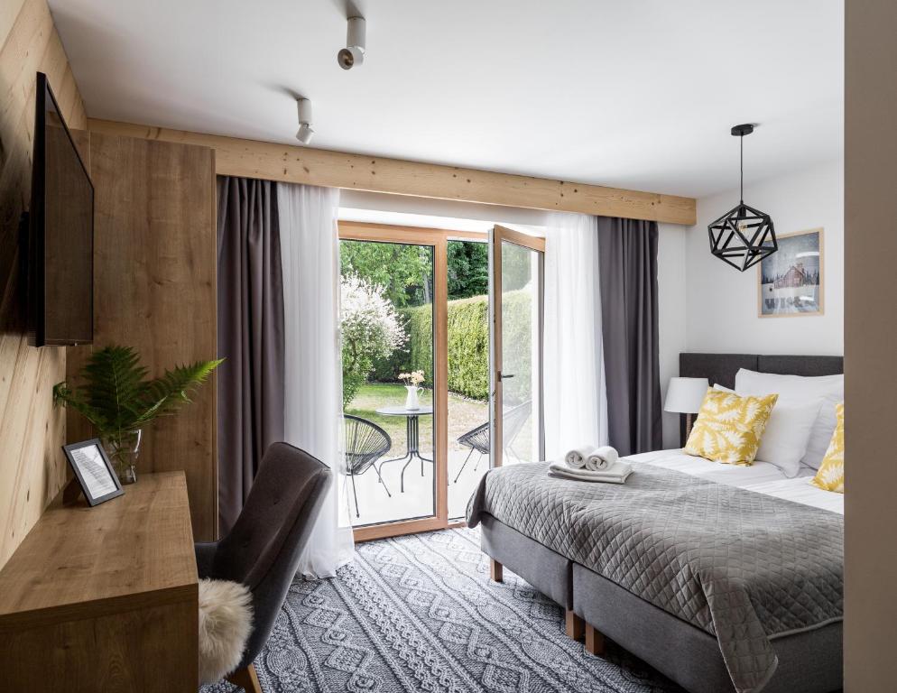 um quarto com uma cama e uma varanda em Villa Górska Ski & Bike em Wisła