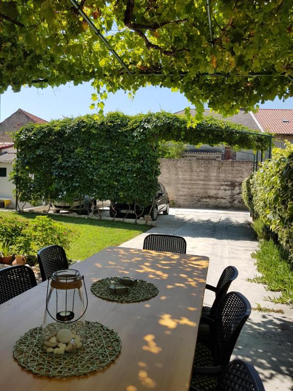 una mesa con sillas y una lámpara de cristal en el patio en Guesthouse Jet en Kaštela