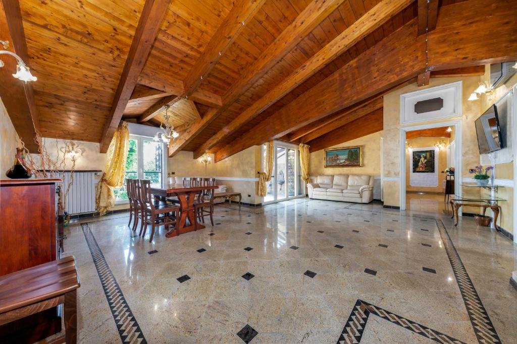een grote woonkamer met een tafel en stoelen bij Casa da Suite Maestosa in Sesto San Giovanni