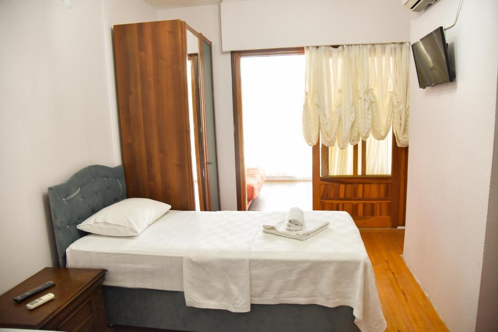 a small room with a bed with a mirror at Balim Sultany in Çeşme