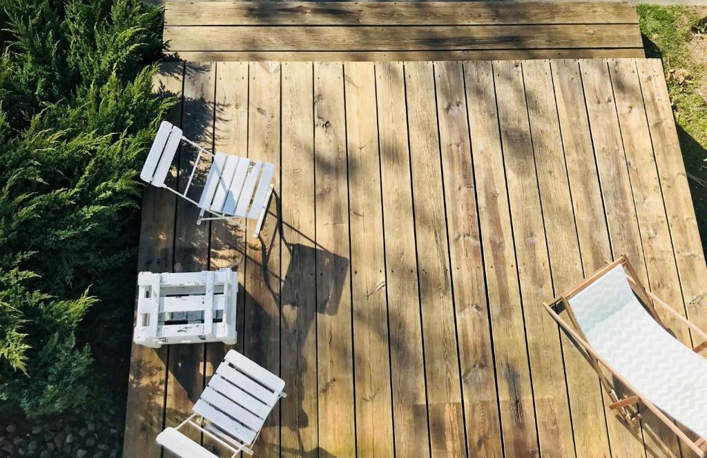 una vista aérea de dos sillas blancas y mesas en una cubierta en Barcelona Rooms, en Mikoszewo