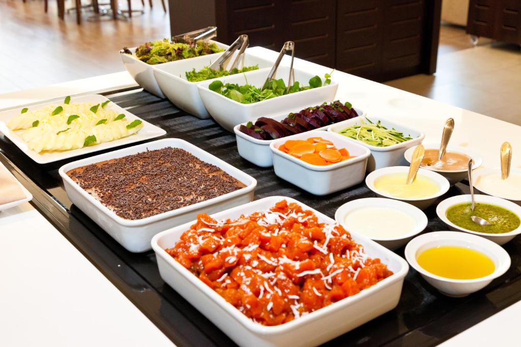 un buffet con muchos platos de comida en una mesa en Hotel Panamby São Paulo, en São Paulo