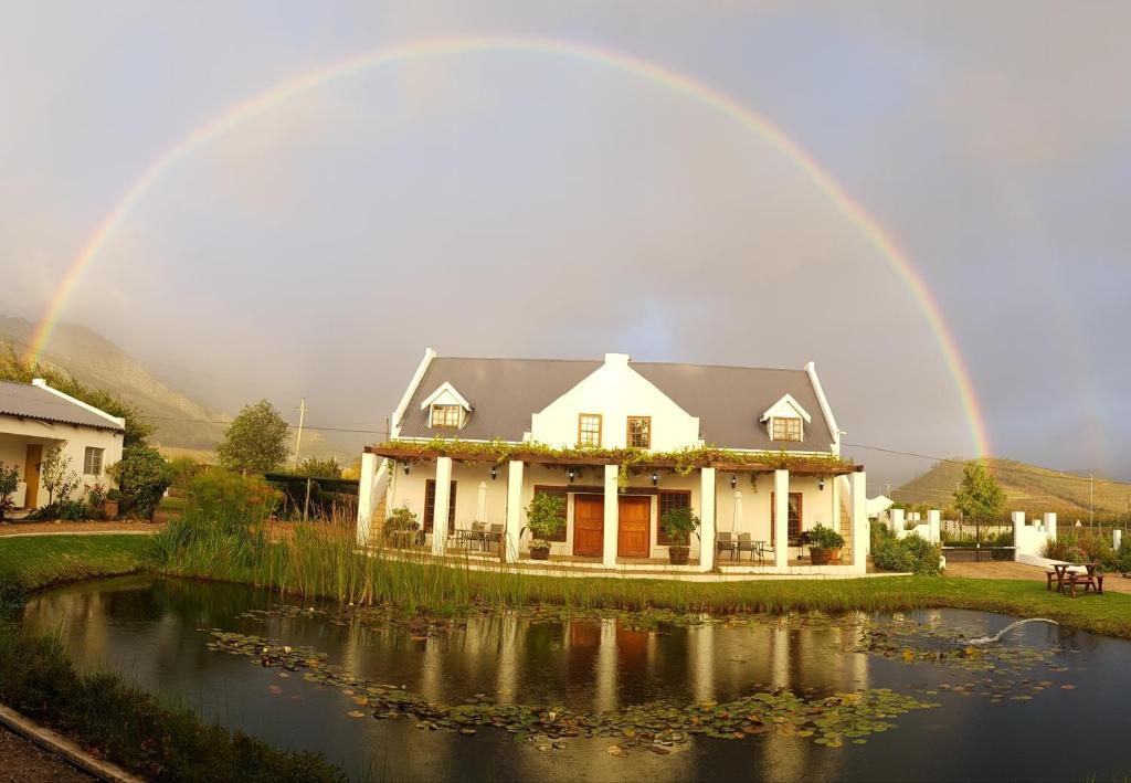 a rainbow over a house with a pond at Chevandeaux 1 - Merlot in Franschhoek