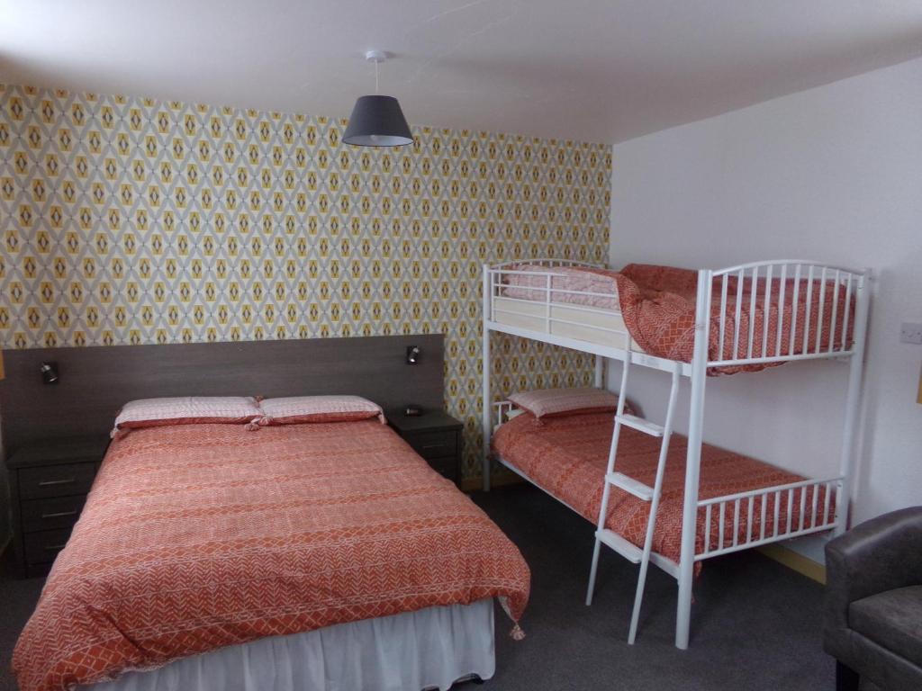 a bedroom with two bunk beds and a ladder at St Annes in Great Yarmouth