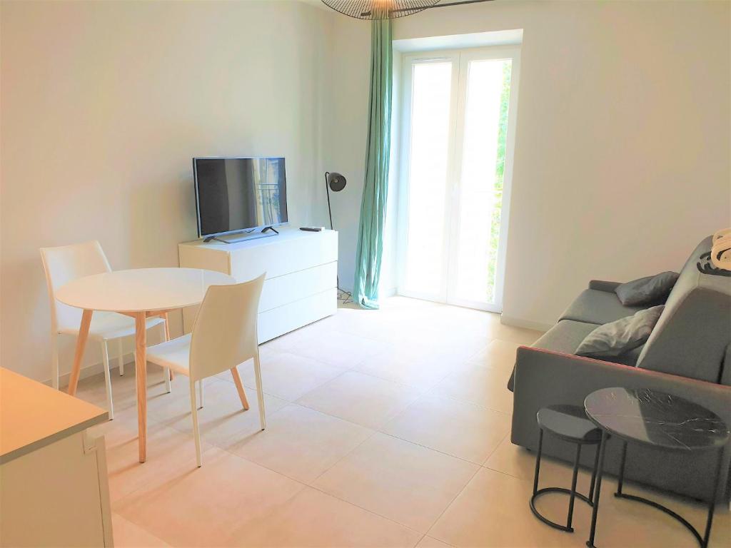 un salon avec un canapé, une table et une télévision dans l'établissement STUDIO CENTRE MER 301, à Nice
