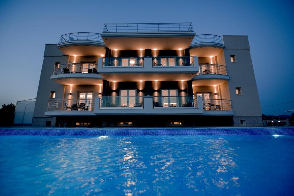 a large building with a swimming pool in front of it at Frunze Luxury Apartments in Nafplio