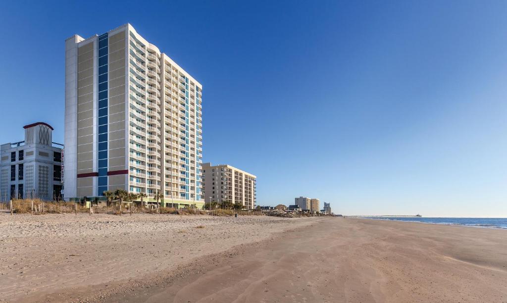 an empty beach with buildings and a building at Club Wyndham Towers on the Grove in Myrtle Beach