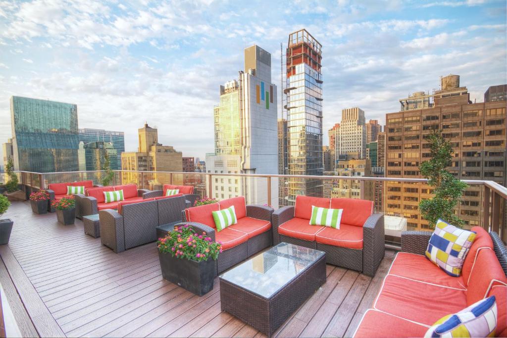 a rooftop deck with couches and tables and a city skyline at Club Wyndham Midtown 45 in New York