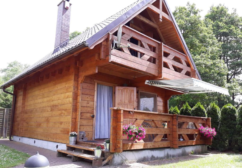 a wooden cabin with a porch and a window at Domek letniskowy Michałówka in Łeba