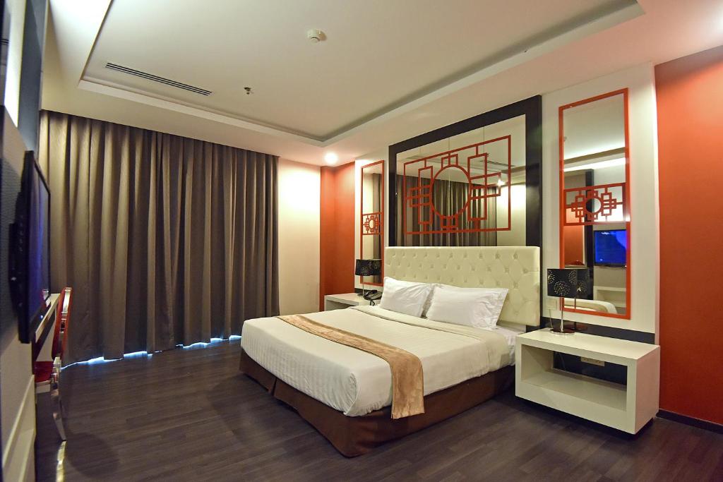 Jindagu Hotel Ipoh في ايبوه: غرفه فندقيه بسرير ونافذه