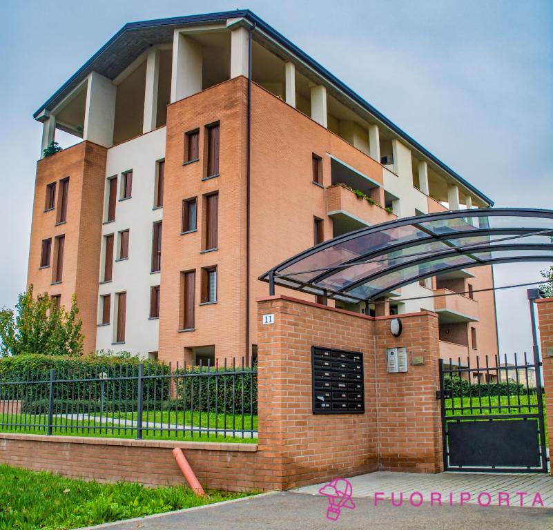 a brick building with a black gate and a building at residenza da Antonia in Parma