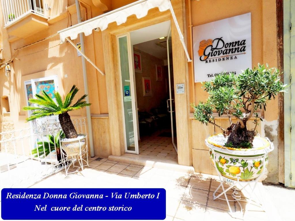 un accès à un bâtiment avec des plantes en pot à l'extérieur dans l'établissement Residenza Donna Giovanna, à Tropea