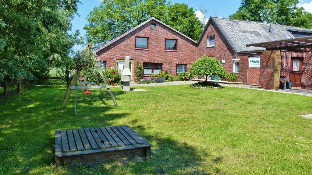 ein Haus mit einem Hof mit einer Bank davor in der Unterkunft Haus NordGlück in Butjadingen