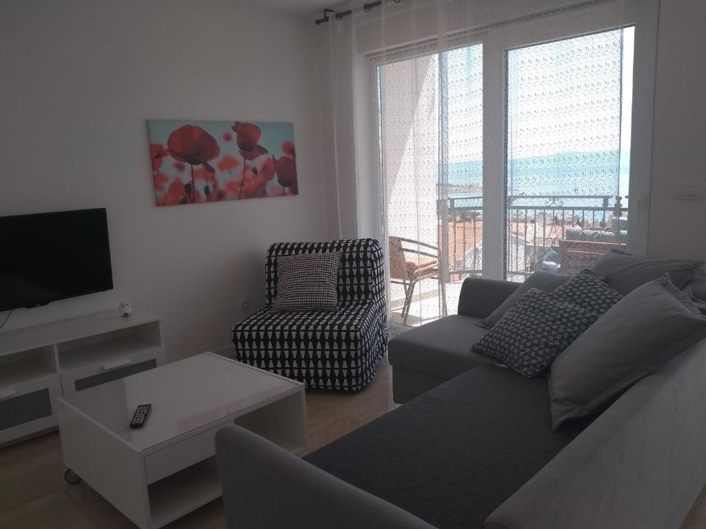 a living room with a couch and a tv at Apartments Viskovic in Makarska