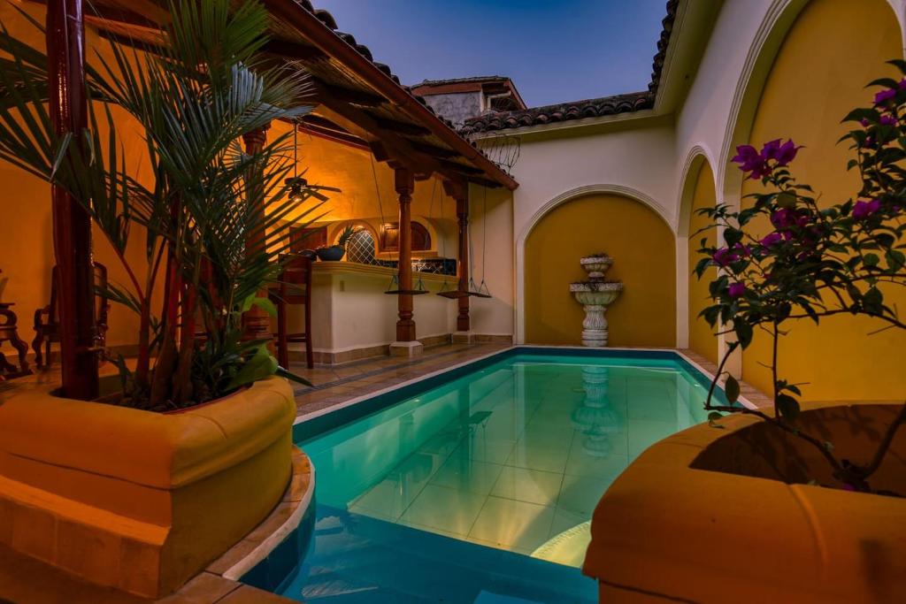 una piscina en una habitación con una casa en Casa de Arcos en Granada
