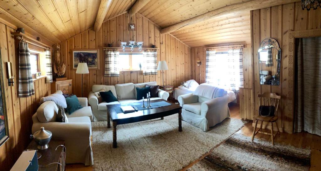 a living room with white furniture and wooden walls at Lillstugan in Sälen