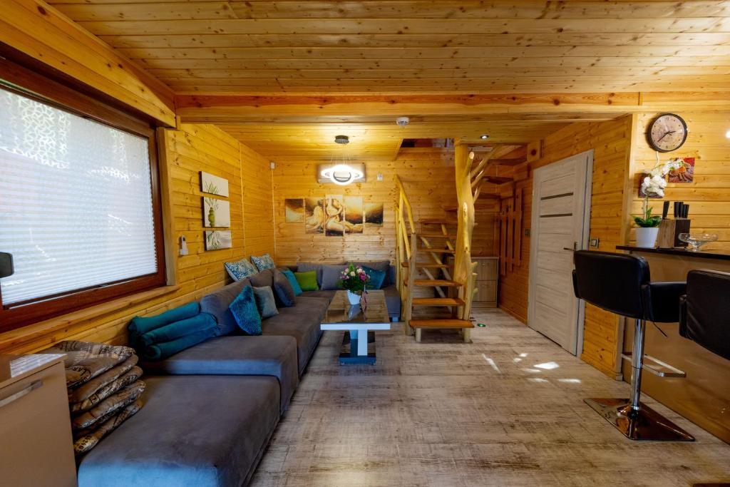 una sala de estar en una cabaña de madera con sofá en OW Magdalena, en Boszkowo
