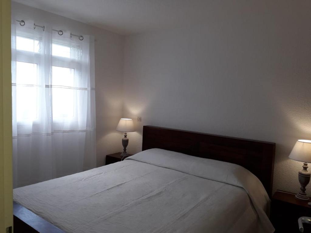 1 dormitorio con 1 cama con ventana y 2 lámparas en Villa d'Alys, en Sainte-Rose