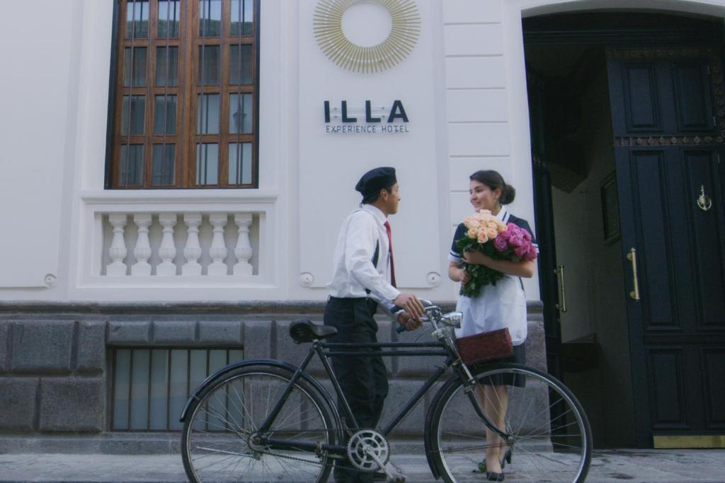 un hombre y una mujer con una bicicleta fuera de un edificio en Illa Experience Hotel, en Quito