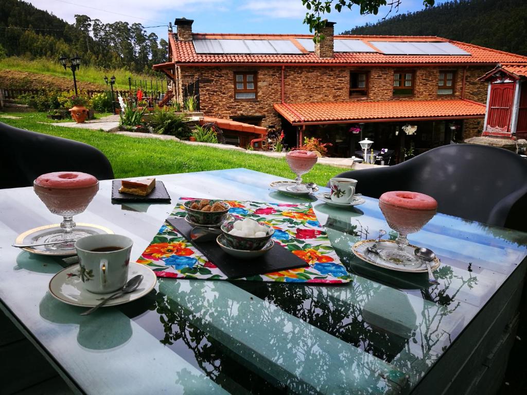 une table avec des assiettes de nourriture et des tasses dessus dans l'établissement Casa do Morcego, à Valdoviño