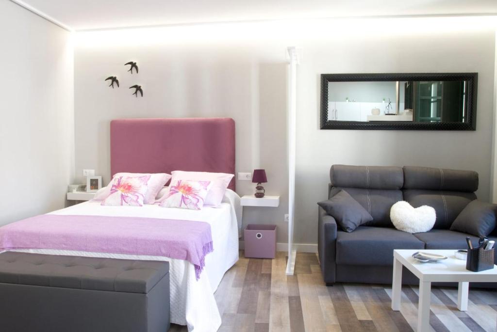 sypialnia z łóżkiem i kanapą w obiekcie Acio Tinto Loft Casco Histórico de Ourense w mieście Ourense