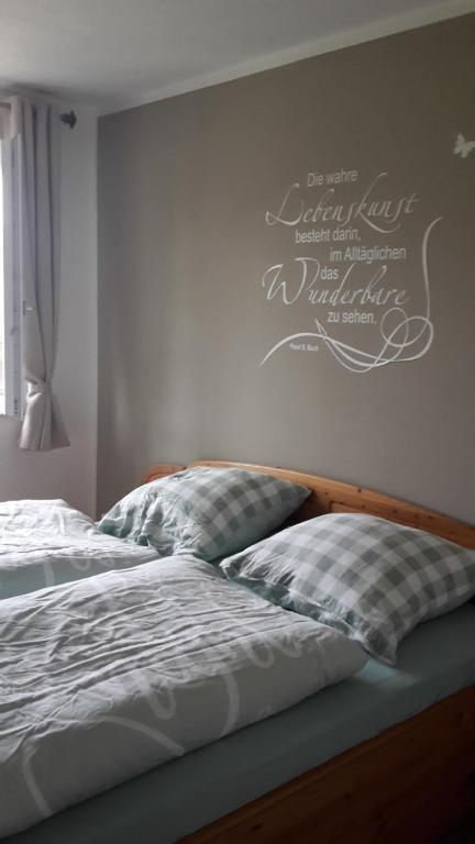 a bedroom with a bed with a writing on the wall at Galloway Hof Wantewitz in Priestewitz