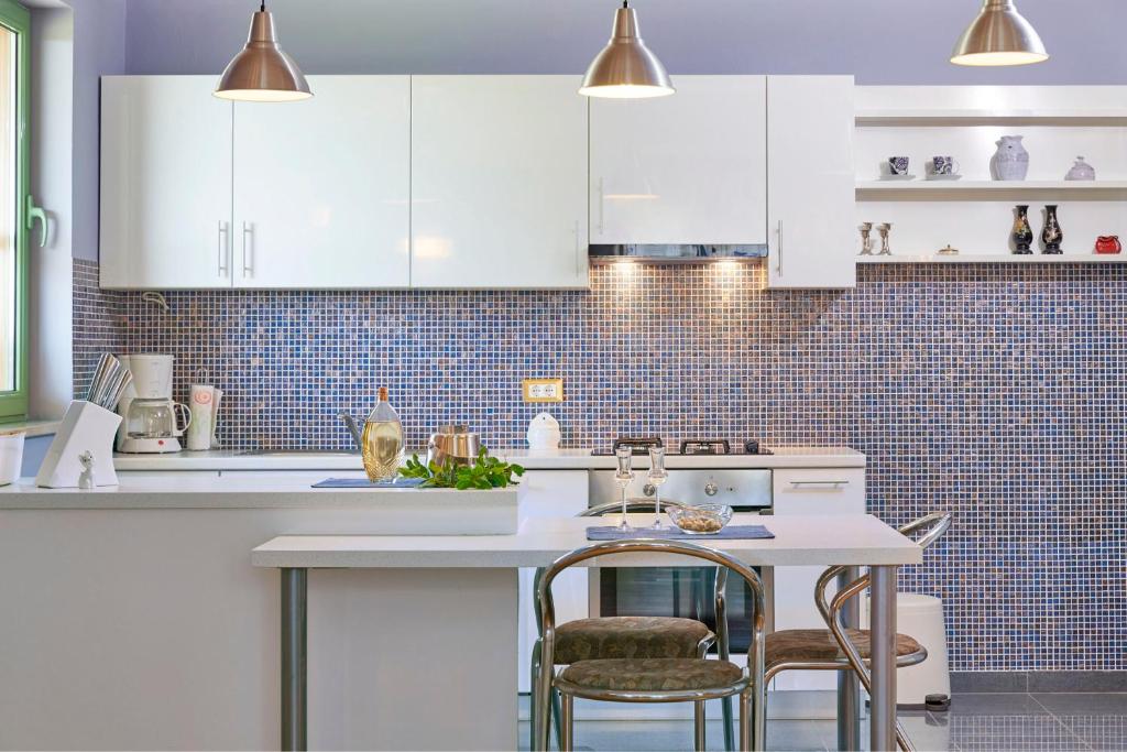a kitchen with white cabinets and a table and chairs at Villa Giardina Apartments in Vinkuran