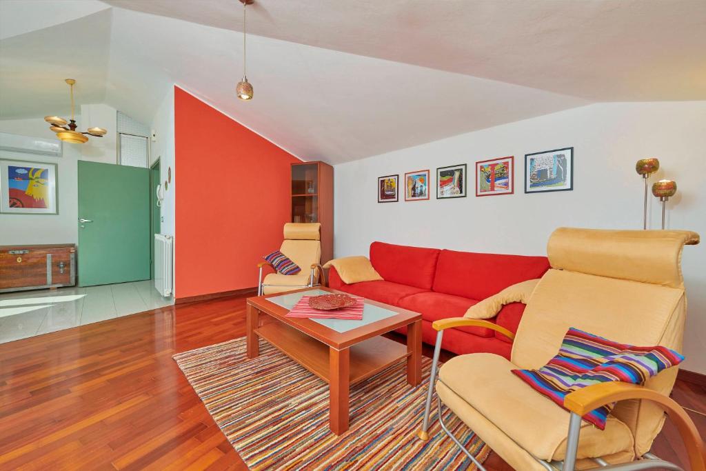 a living room with a red couch and a table at Villa Giardina Apartments in Vinkuran